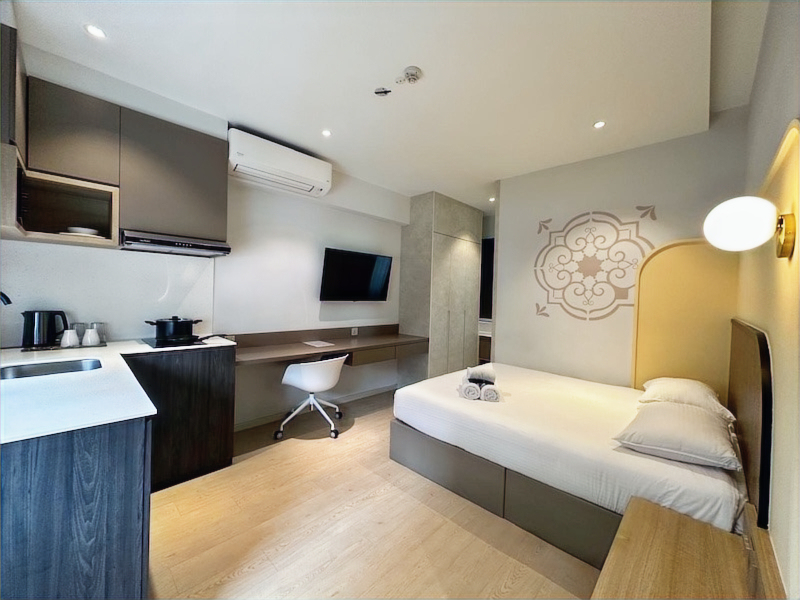 A studio at the ISA Hotel & Apartment Hotel in Katong — kitchenette, work desk and bed, thoughtfully laid out in one bright, light-filled room.