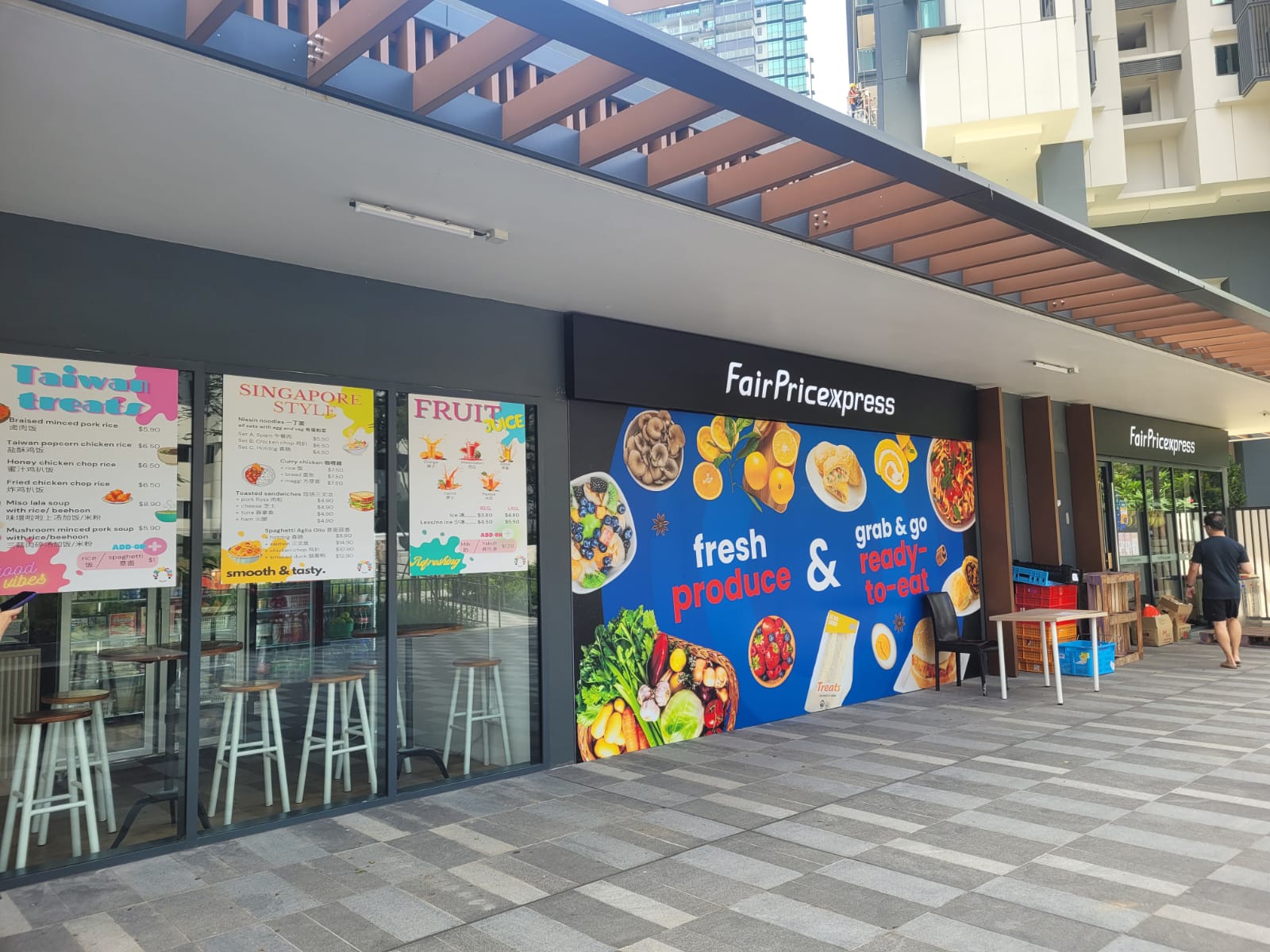 A FairPrice Xpress at the foot of the towers — groceries, fresh produce and grab-and-go meals without crossing a road.