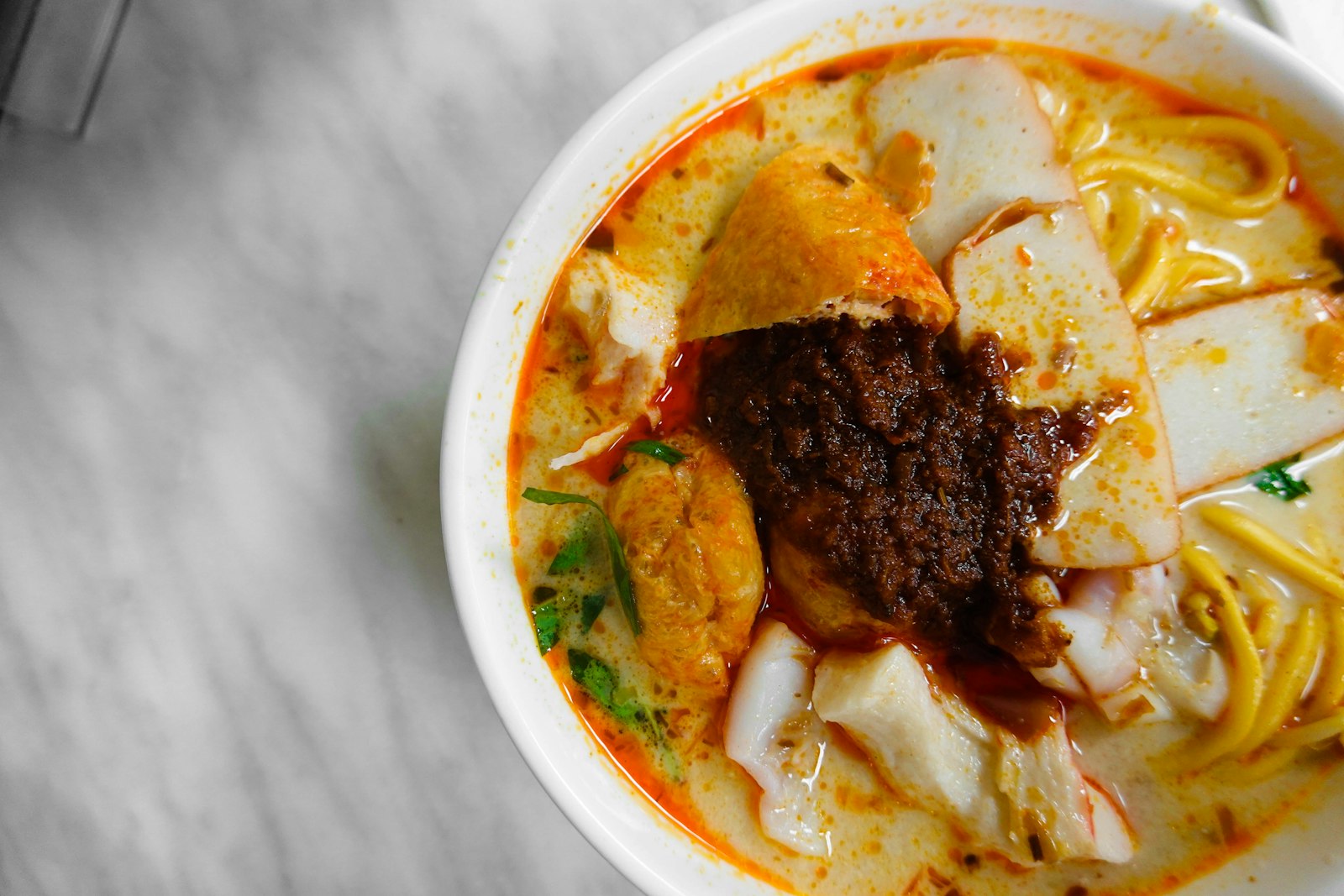 A bowl of laksa — rich, coconut-y and eaten with a spoon — the dish Katong is known for.