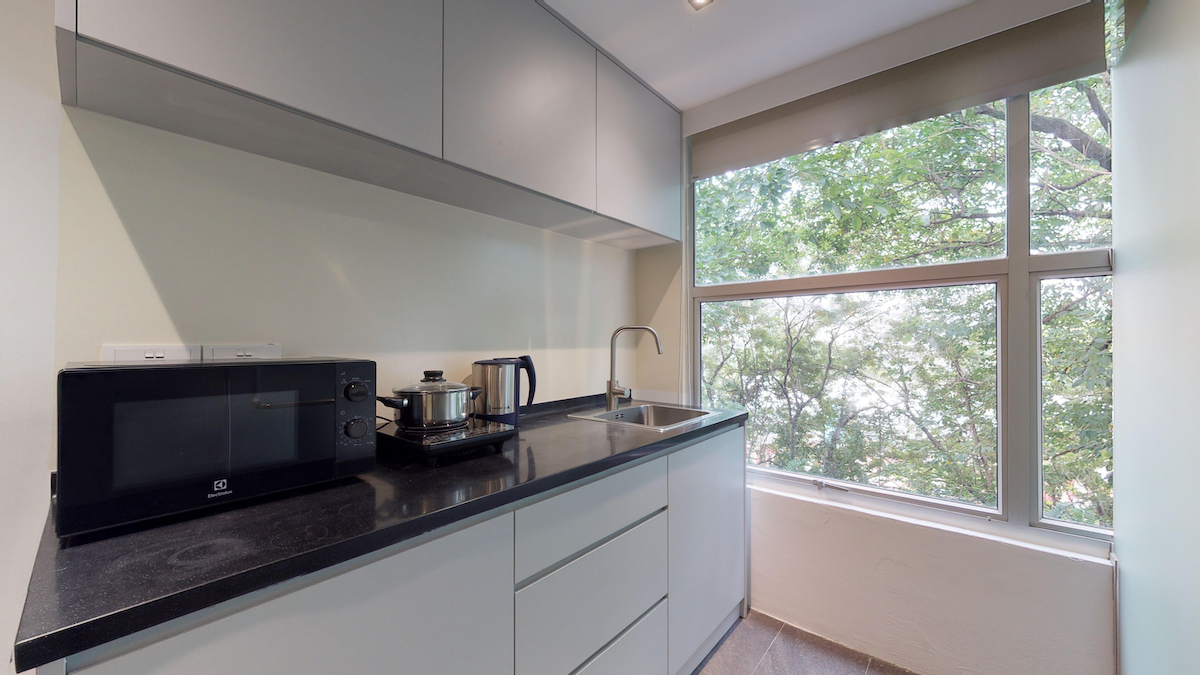 A serviced studio apartment at ISA @ Raeburn Park — its own kitchenette and a leafy outlook, for stays from a week to many months.
